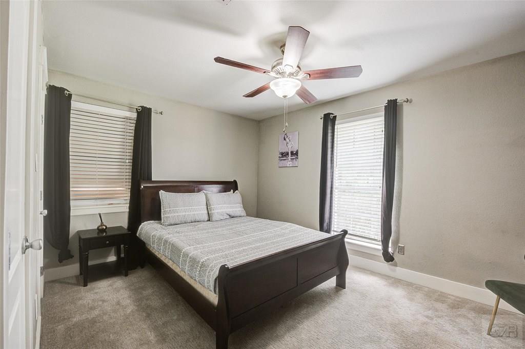 10213 Stewart Road Galveston, TX 77554 - Photo 37 of 49 a bedroom with a large bed and a chandelier