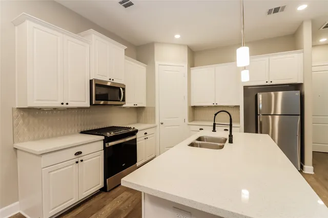 a kitchen with stainless steel appliances granite countertop a sink and cabinets