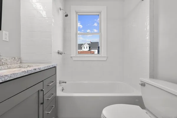 a bathroom with a granite countertop toilet sink and bathtub