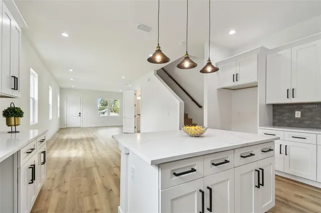 a kitchen with kitchen island a stove and a table