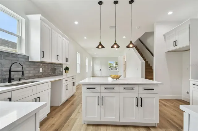 a kitchen with white cabinets and sink
