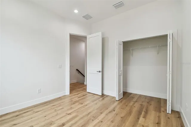an empty room with wooden floor and entrance