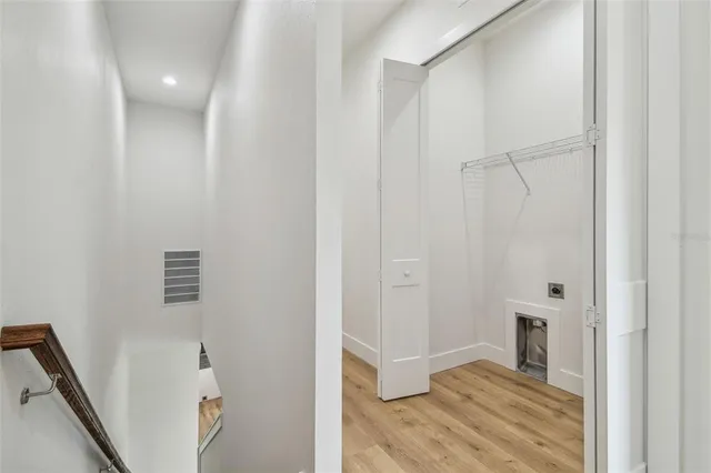 a view of a hallway with wooden floor and closet