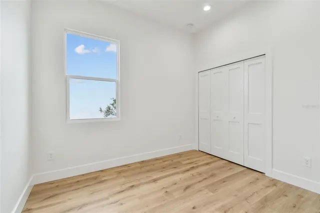 an empty room with wooden floor and closet