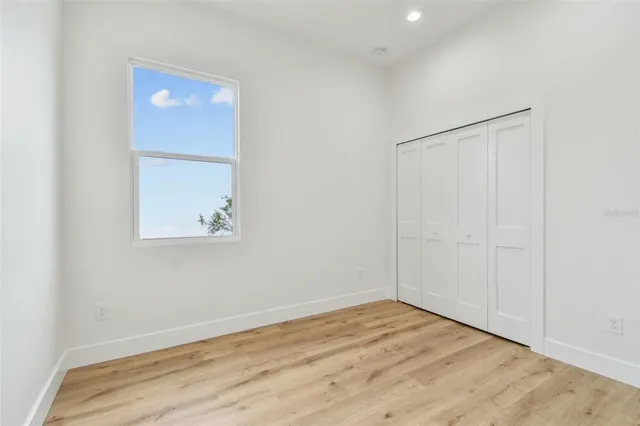 an empty room with wooden floor and closet