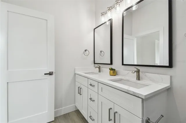 a bathroom with a double vanity sink and a mirror