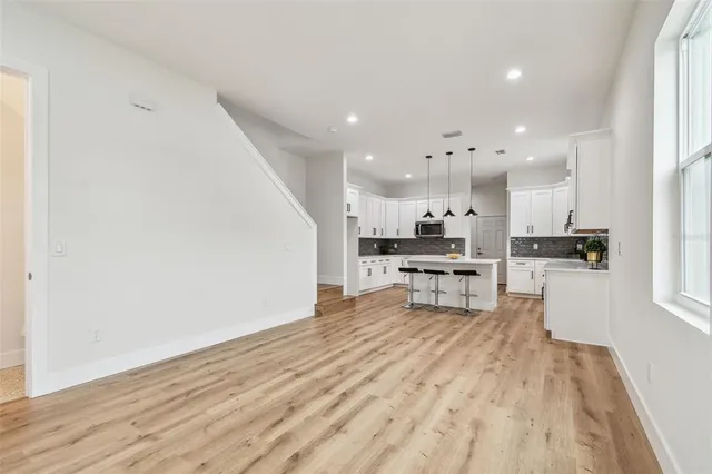 a kitchen with stainless steel appliances kitchen island granite countertop a refrigerator and cabinets