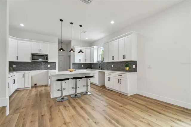 a kitchen with kitchen island a sink and a stove top oven