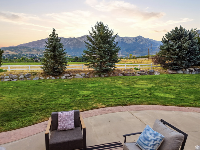 702 Alpine Highway Alpine, UT 84004 - Photo 83 of 83 Expansive backyard featuring a large concrete patio with a decorative border, a manicured lawn, and mature evergreen trees