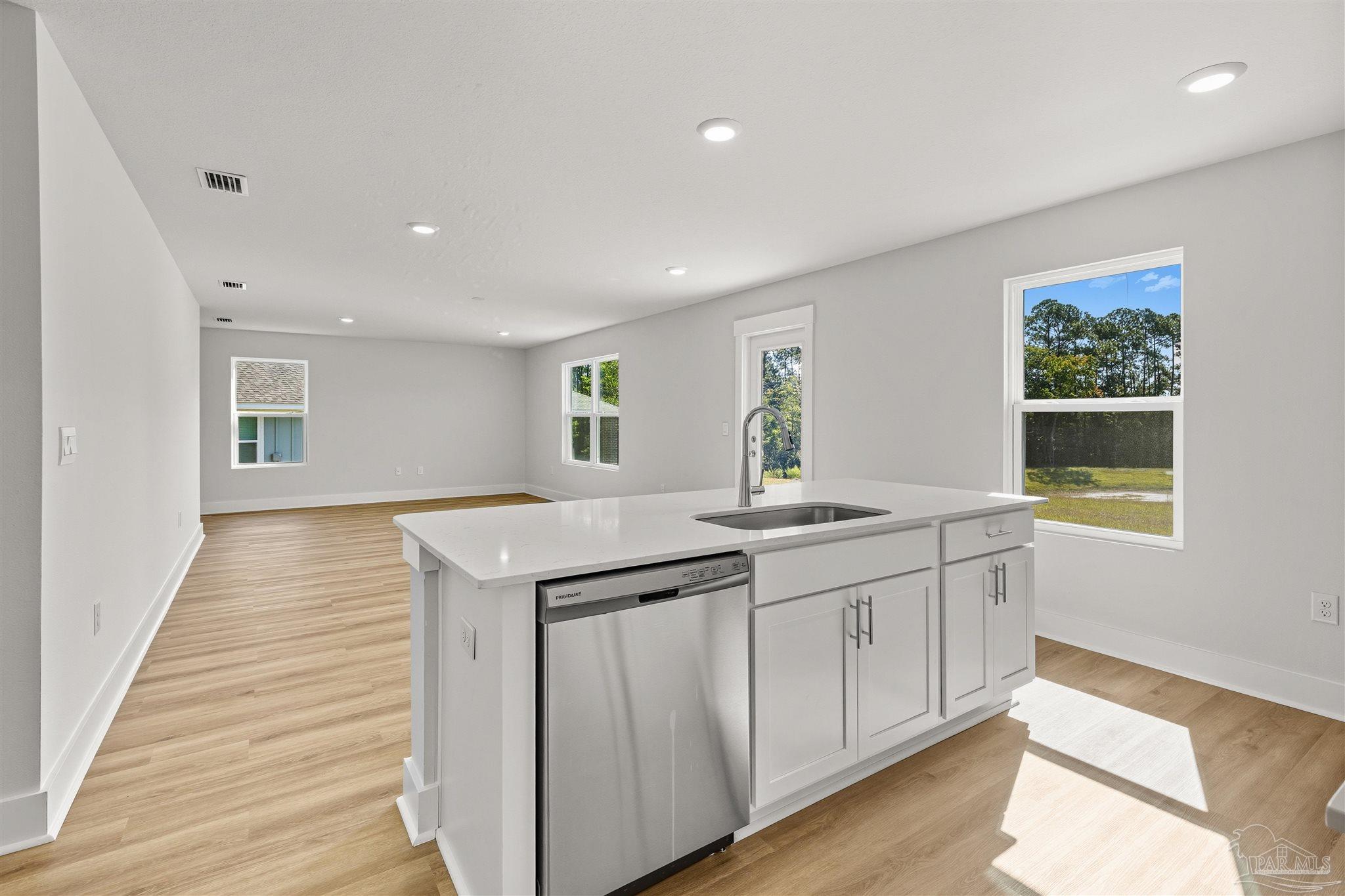 3162 Serviceberry Road Cantonment, FL 32533 - Photo 11 of 35 a kitchen with granite countertop a sink and a stove with wooden floor