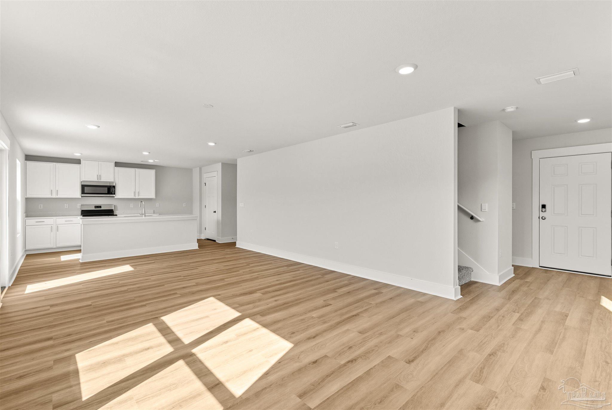 3162 Serviceberry Road Cantonment, FL 32533 - Photo 8 of 35 a view of empty room with wooden floor and kitchen