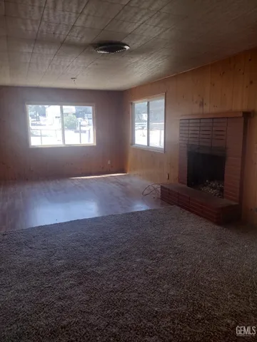 an empty room with windows and fireplace