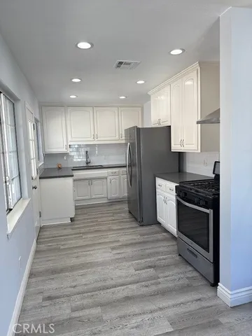 a kitchen with stainless steel appliances granite countertop a stove a refrigerator and a microwave