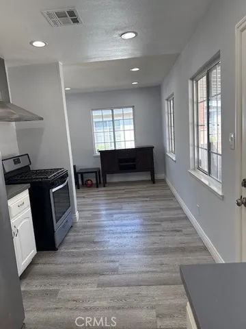 a view of kitchen with microwave a stove and wooden floor