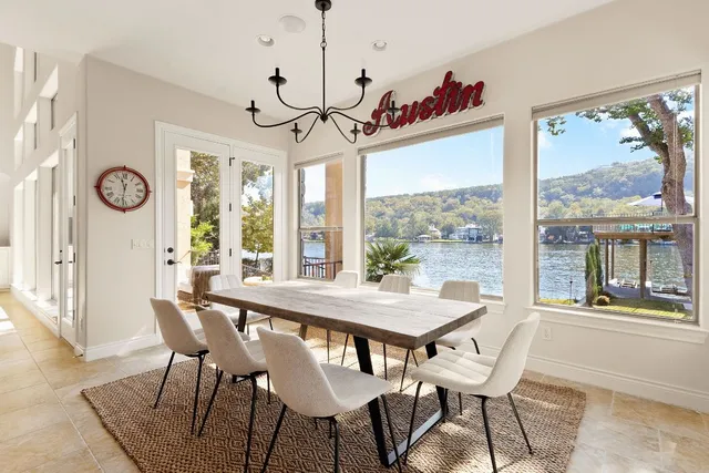 a view of a dining room with furniture large windows and wooden floor