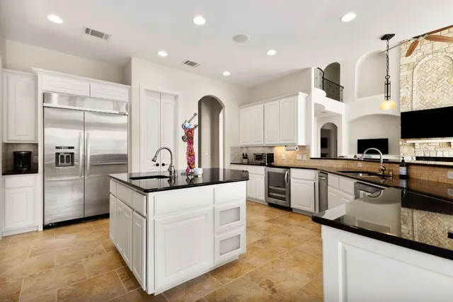 a kitchen with granite countertop a sink and stainless steel appliances