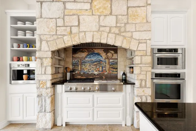 a kitchen with stainless steel appliances kitchen island granite countertop a stove and a microwave