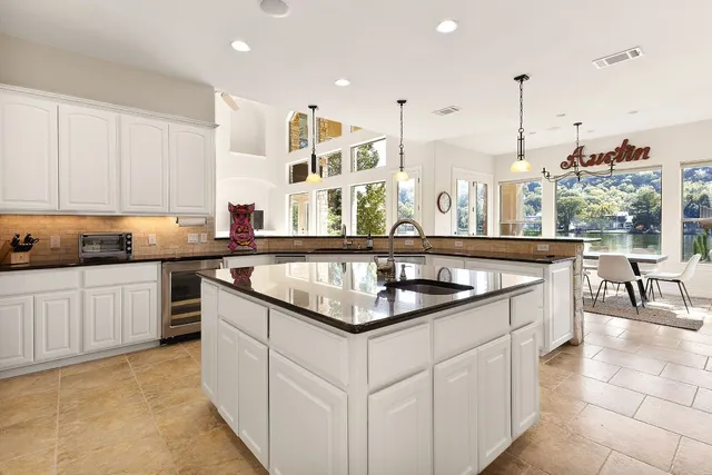 a kitchen with granite countertop a sink and white cabinets