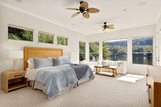 a bedroom with a bed couch and large window