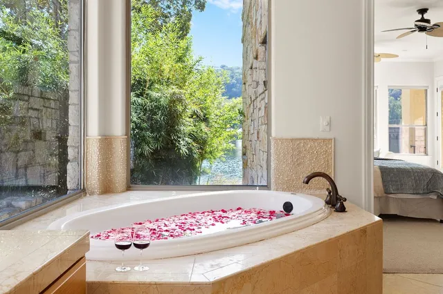 a white bath tub sitting in a bathroom next to a window