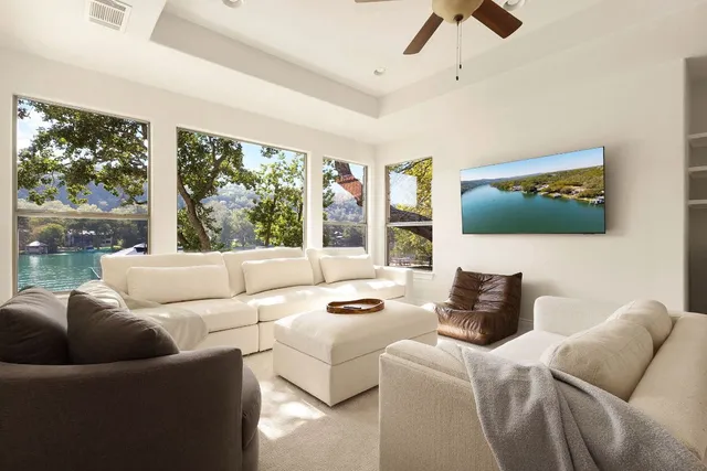 a living room with furniture a flat screen tv and a large window