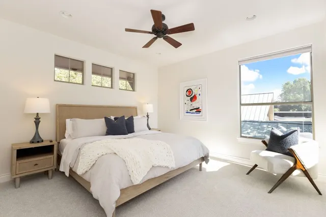 a bedroom with a bed a couch and a large window