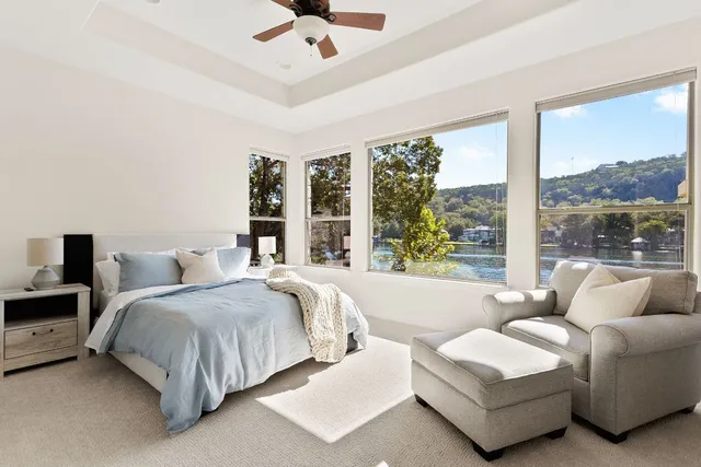 a spacious bedroom with a bed couch and large window