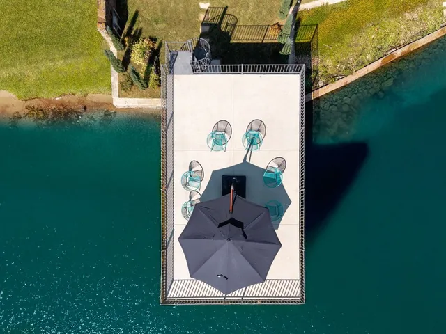 an aerial view of ocean and residential houses with outdoor space