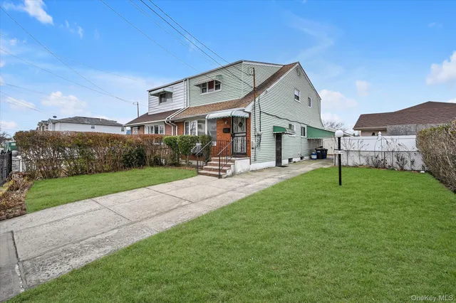 a view of a big house with a big yard and large trees