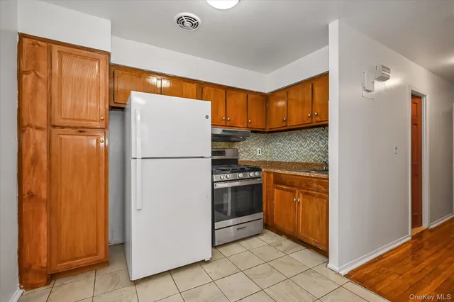 a kitchen with stainless steel appliances granite countertop a refrigerator and a sink