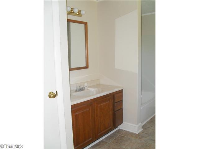 6755 Ridge Road Tobaccoville, NC 27050 - Photo 14 of 16 Master Bath/Spa. Wonderful master bath has a linen closet, single sink vanity, one piece tub/shower and window.