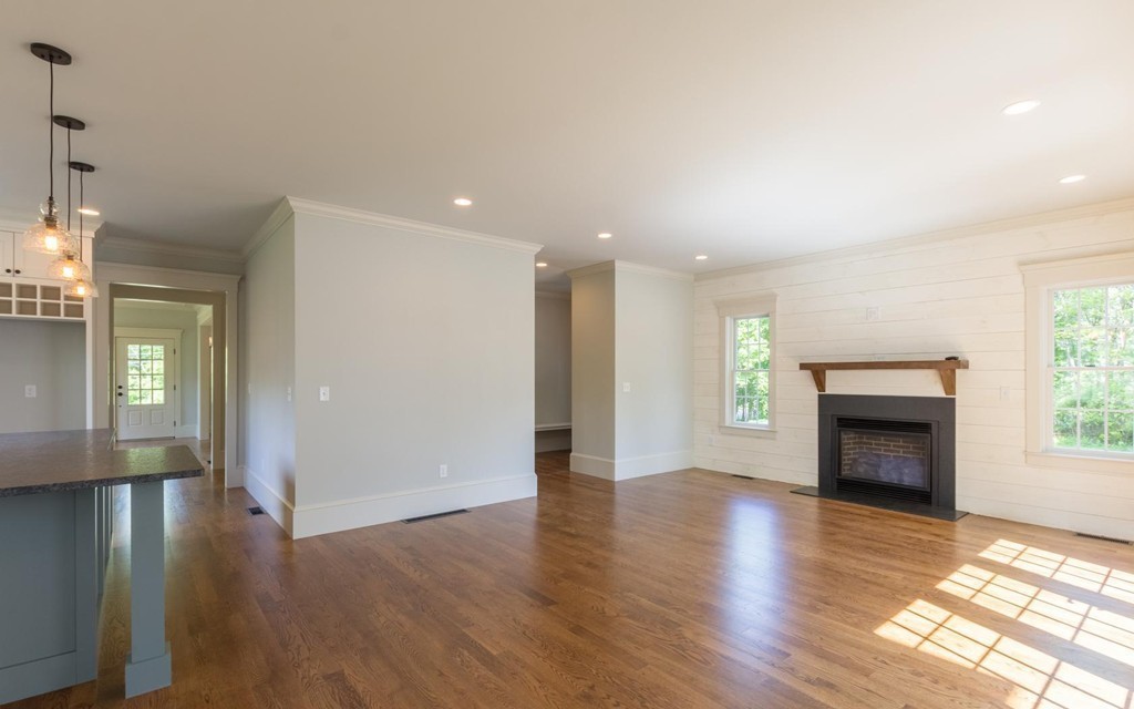 999 Main Street Hanover, MA 02339 - Photo 7 of 28 an empty room with wooden floor fireplace and windows