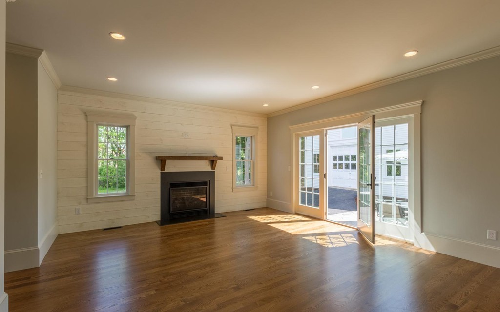999 Main Street Hanover, MA 02339 - Photo 8 of 28 an empty room with wooden floor fireplace and windows