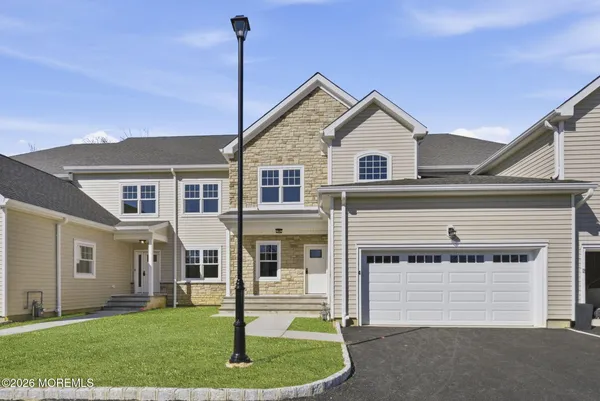a view of a house with a yard and large tree