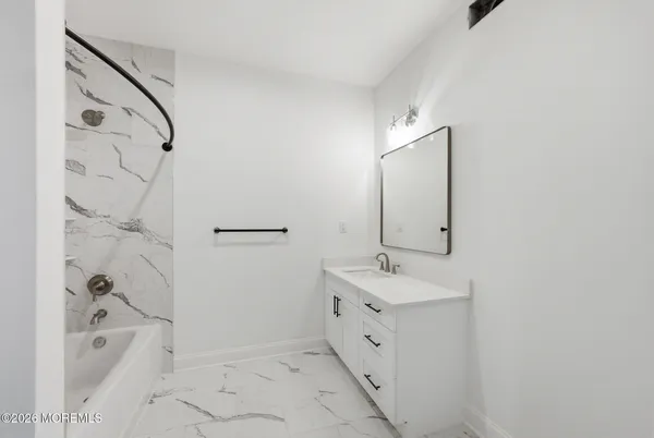 a bathroom with a tub sink and mirror