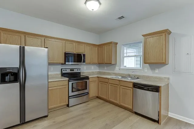 a kitchen with a sink stove and refrigerator