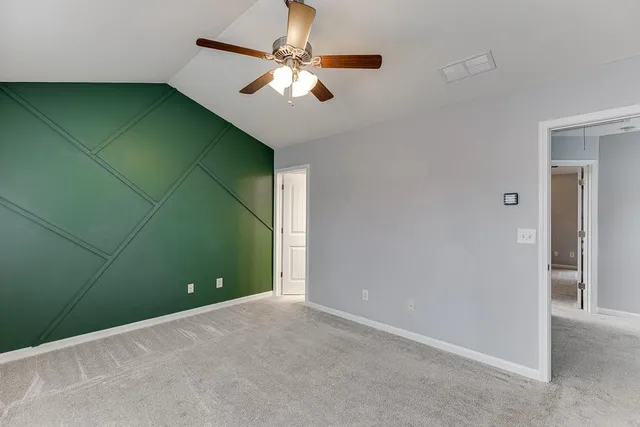 an empty room with a fan & a fan