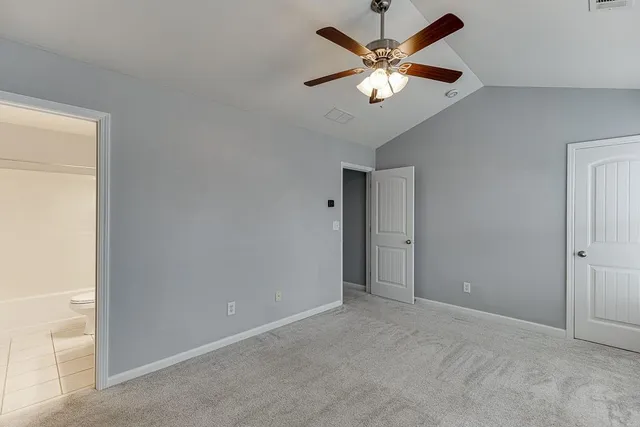 an empty room with closet and a ceiling fan