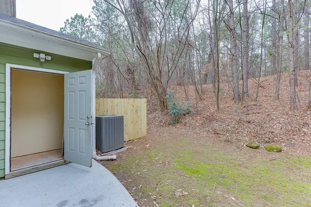 a view of a house with backyard and trees