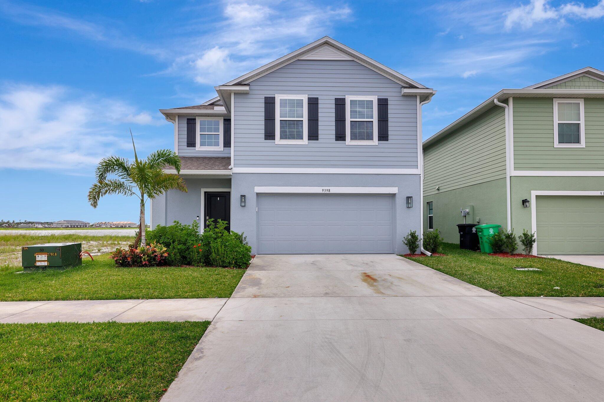 9398 Serapis Way Port St. Lucie, FL 34987 - Photo 1 of 50 a front view of a house with a yard and garage