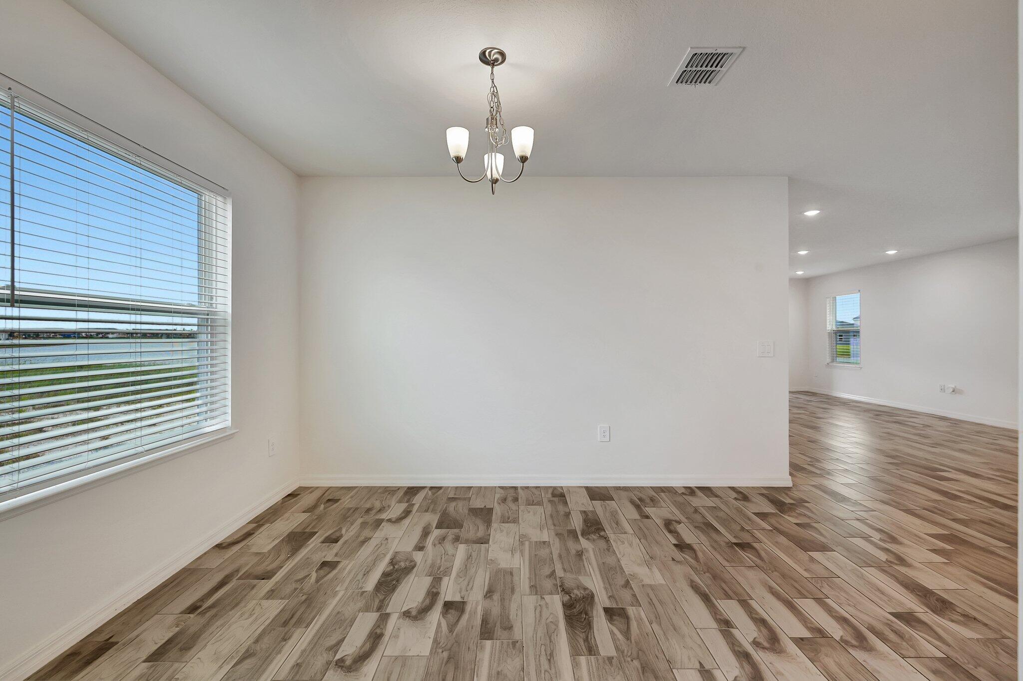 9398 Serapis Way Port St. Lucie, FL 34987 - Photo 13 of 50 a view of empty room with wooden floor and fan