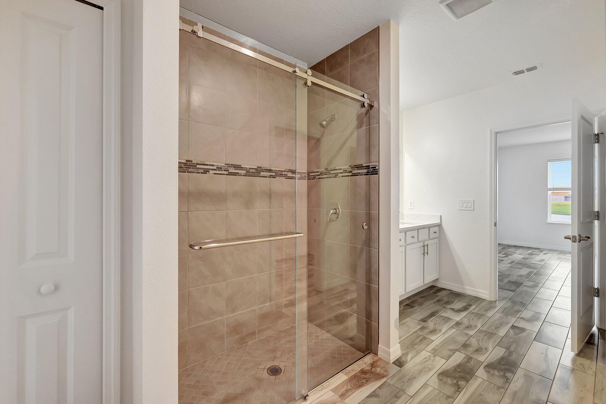 9398 Serapis Way Port St. Lucie, FL 34987 - Photo 19 of 50 a bathroom with a glass shower door