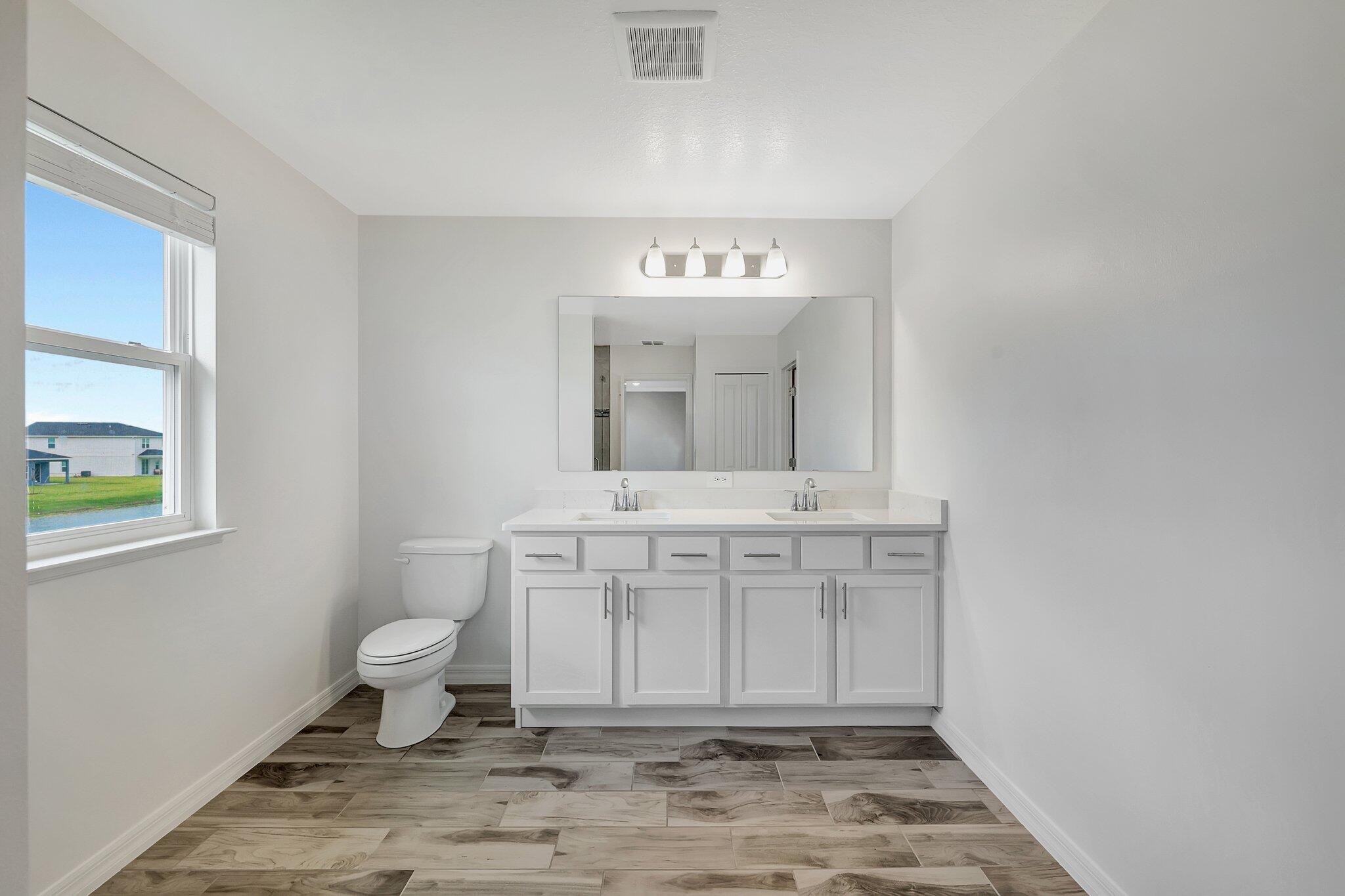 9398 Serapis Way Port St. Lucie, FL 34987 - Photo 33 of 50 a view of a bathroom with toilet sink and mirror