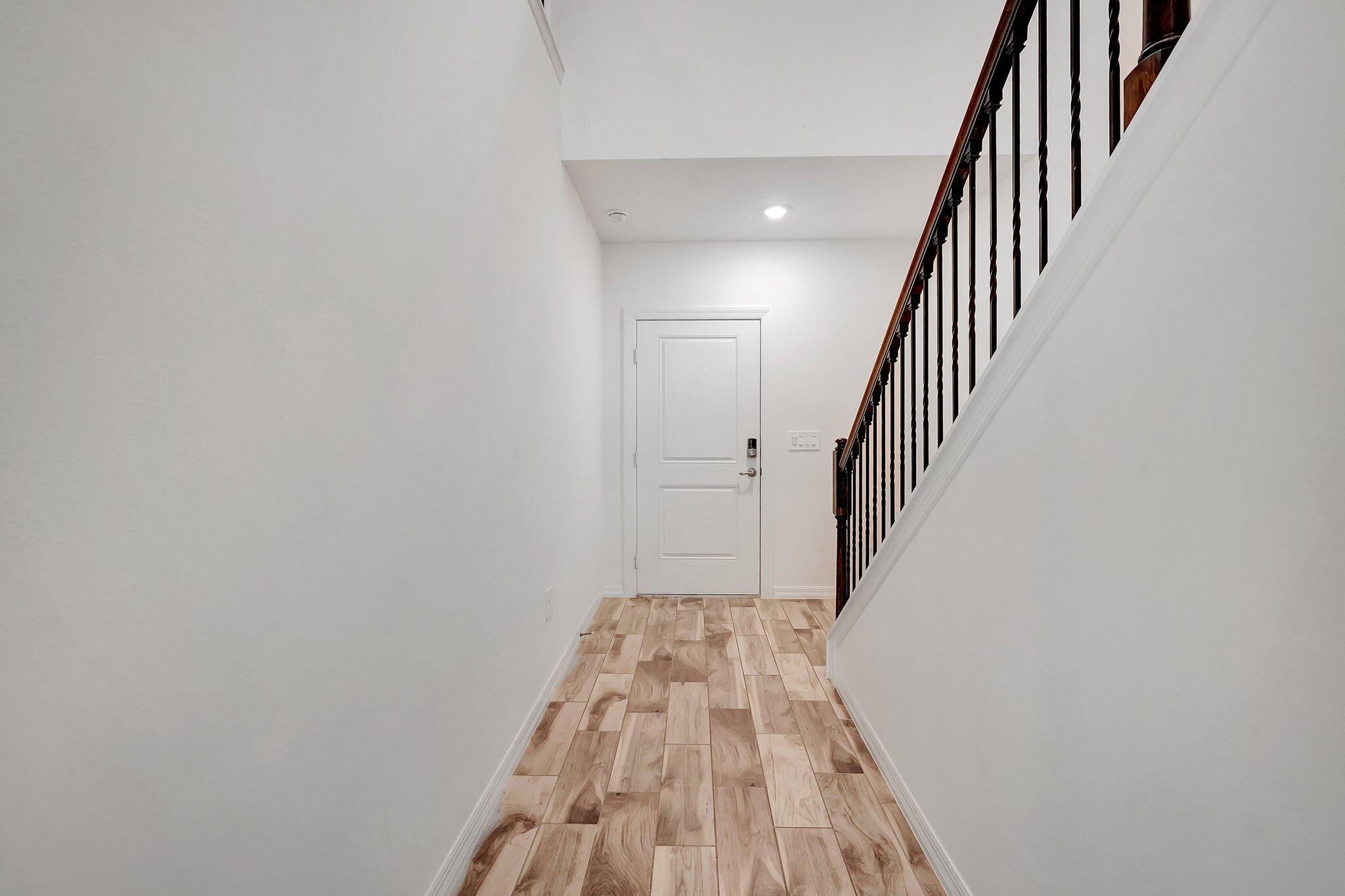 9398 Serapis Way Port St. Lucie, FL 34987 - Photo 36 of 50 a view of a hallway with wooden floor and staircase