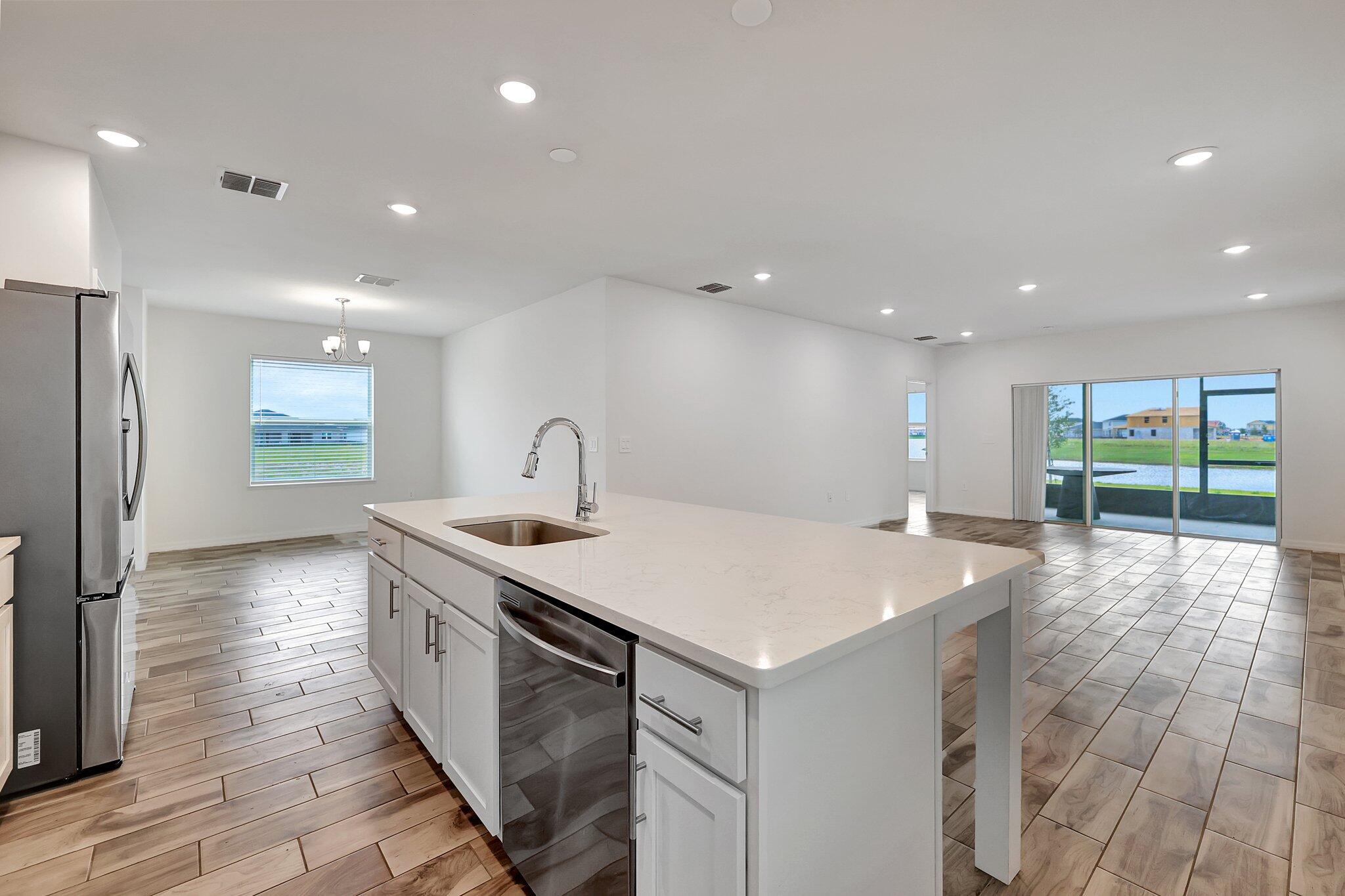 9398 Serapis Way Port St. Lucie, FL 34987 - Photo 7 of 50 a kitchen with a sink and a refrigerator