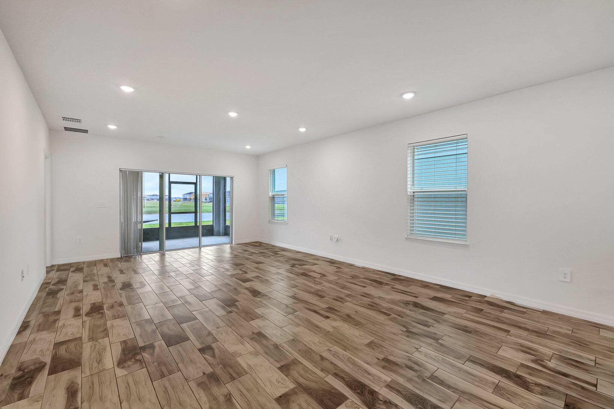 9398 Serapis Way Port St. Lucie, FL 34987 - Photo 9 of 50 a view of an empty room with wooden floor and a window