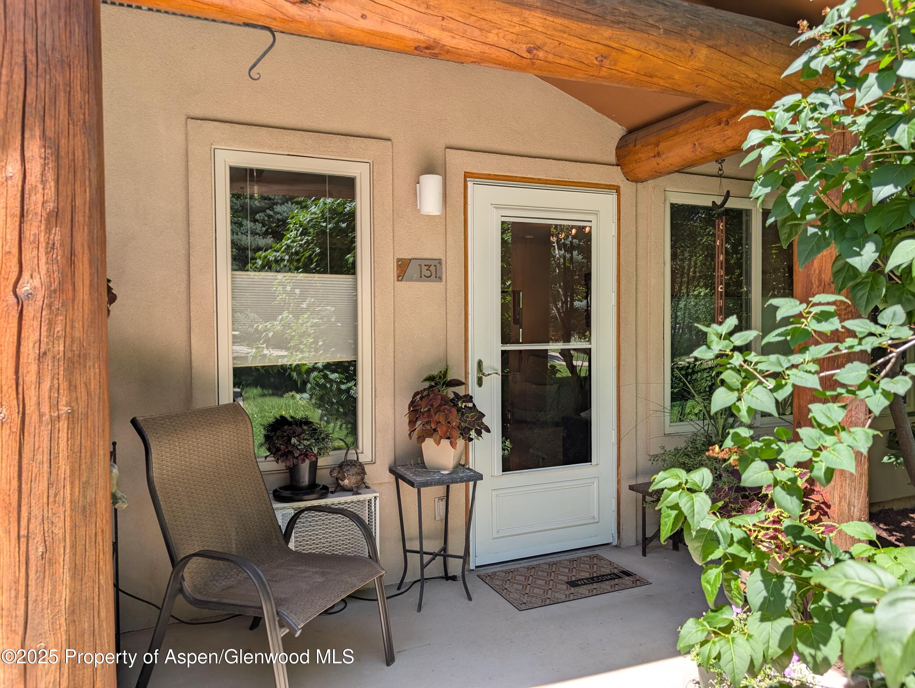 a porch with a bench and potted plants