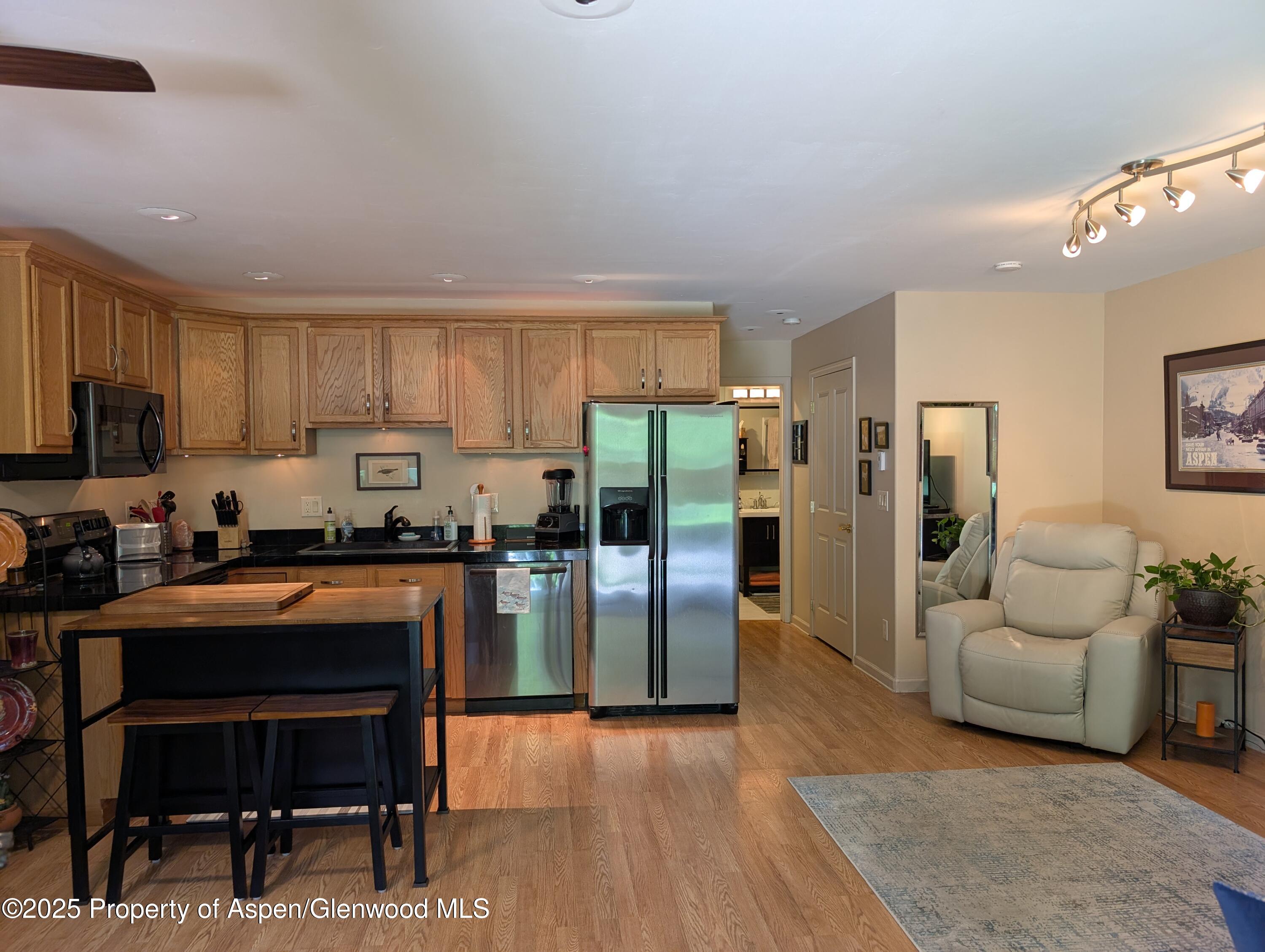 1400 East Valley Road, Unit 7 Basalt, CO 81621 - Photo 2 of 8 a kitchen with stainless steel appliances granite countertop a refrigerator stove microwave and sink