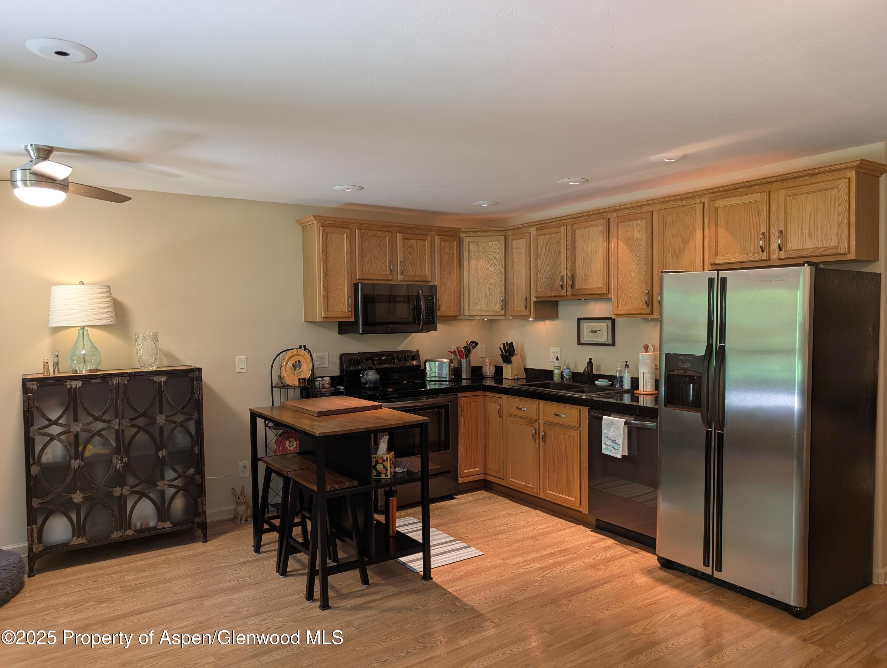 1400 East Valley Road, Unit 7 Basalt, CO 81621 - Photo 3 of 8 a kitchen with kitchen island granite countertop a stove top oven a sink a dining table and chairs