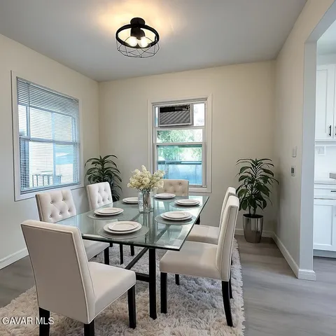 a dining room with furniture potted plants and wooden floor